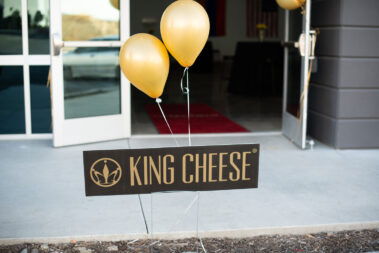 King Cheese plaque with yellow balloons taped to it.