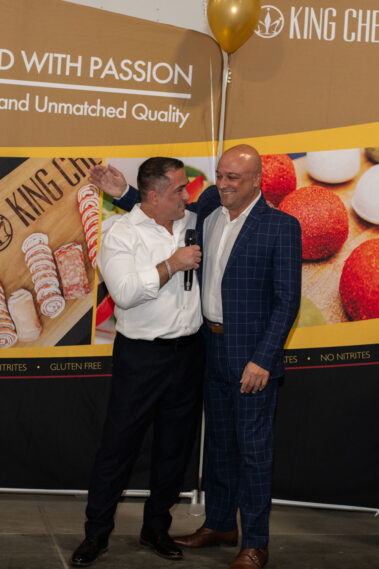 Vicken Aghchikian standing with a man talking to him with microphone in hand.