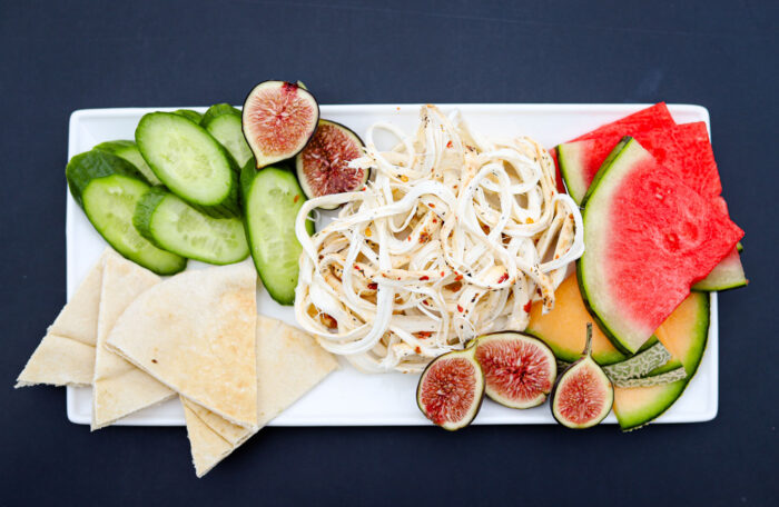 String cheese, marinated flavor on a platter with fruits and vegetables from King Cheese.